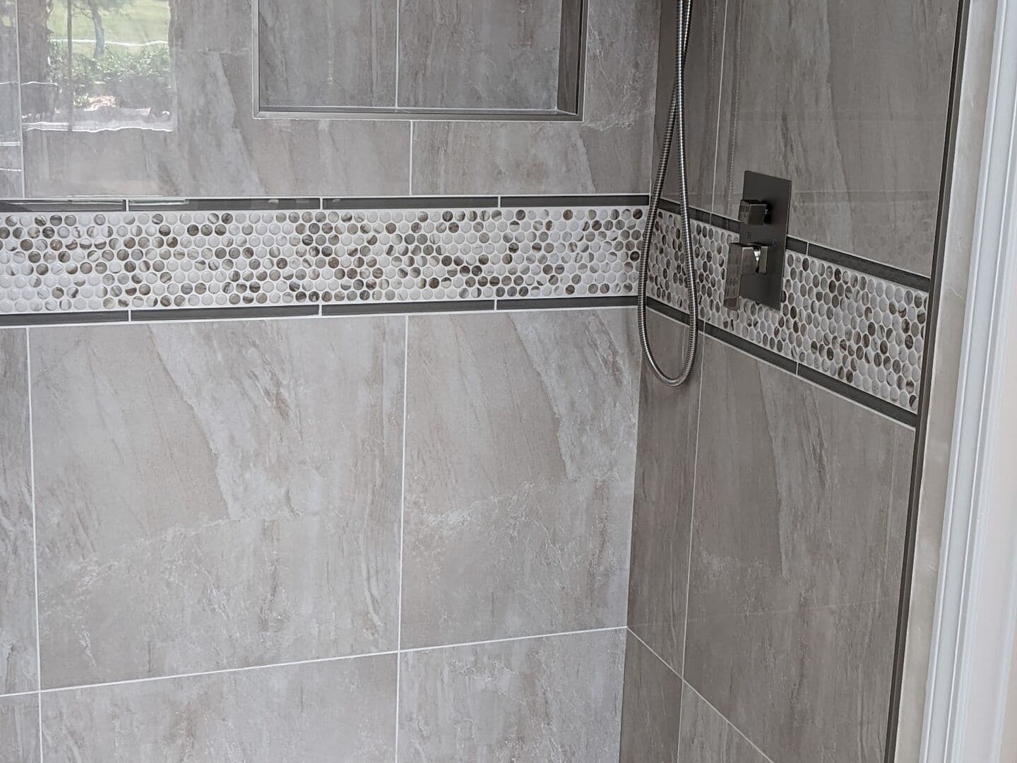 Shower with onyx-look porcelain walls, a glass mosaic band, recessed niche and built-in bench