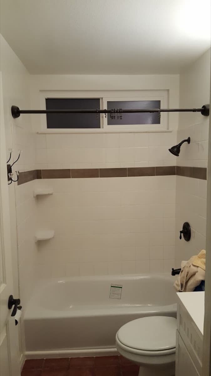 After: new tub surround tile with a mosaic accent band