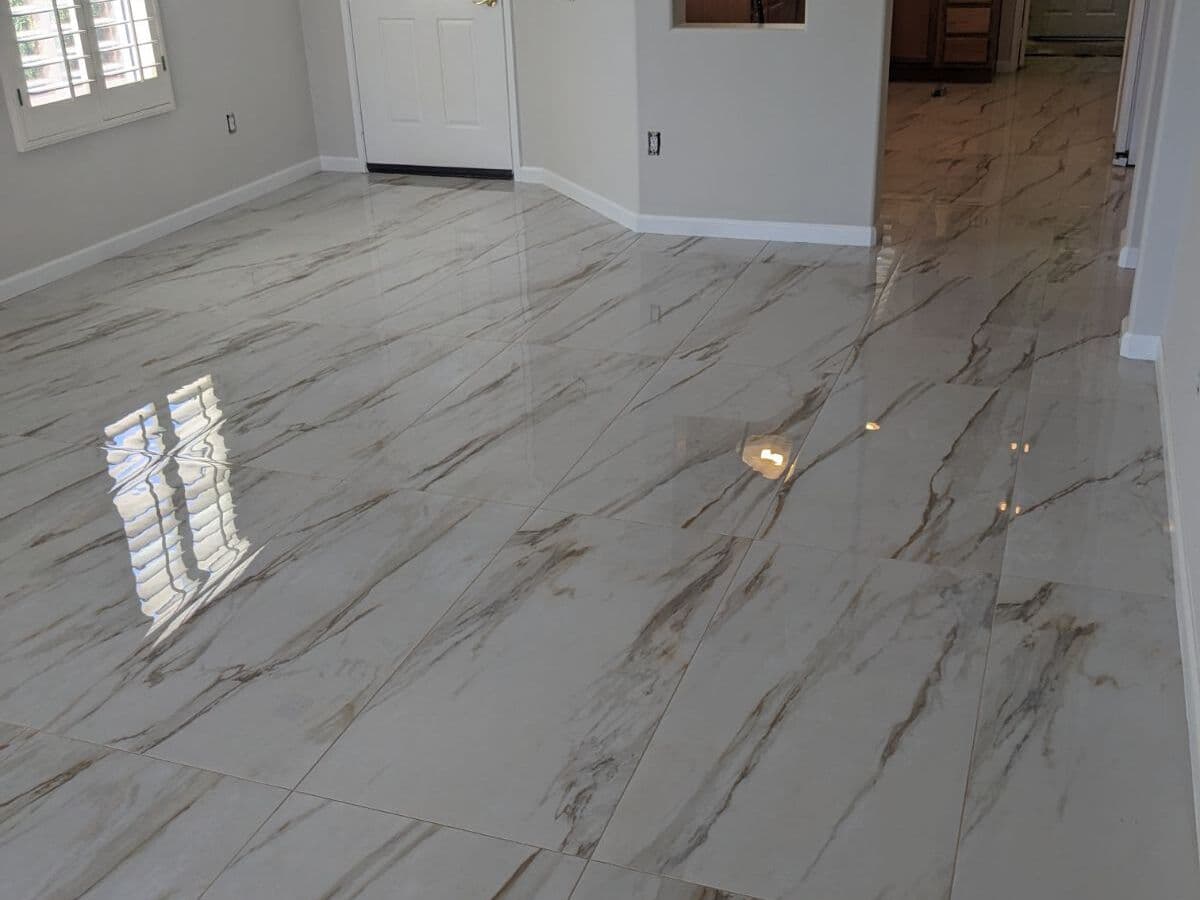 Polished marble-look porcelain floor in a living room with plantation shutters