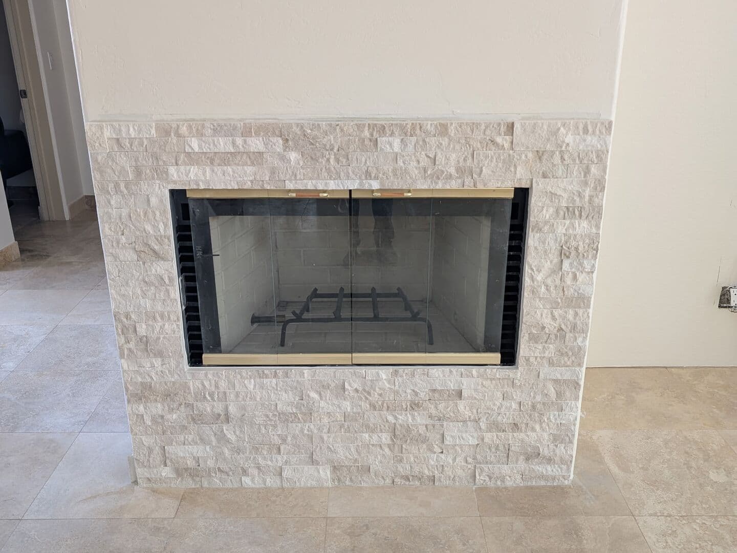 After: the surround faced in cream stacked stone ledger panels