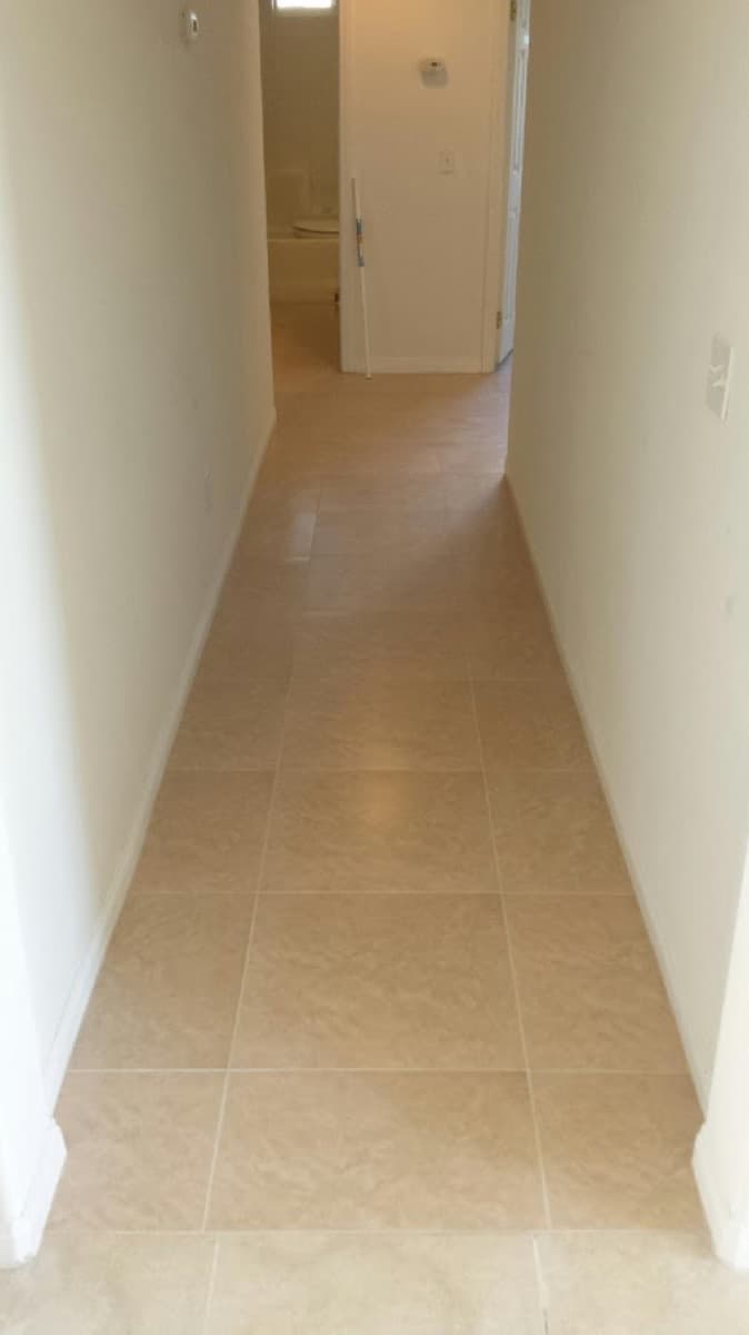 Beige ceramic tile laid straight down a hallway