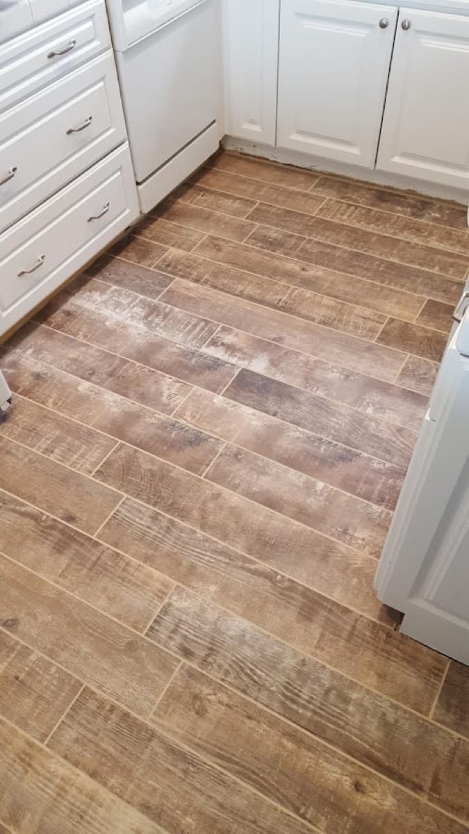 After: wood-look porcelain plank floor laid straight through the kitchen