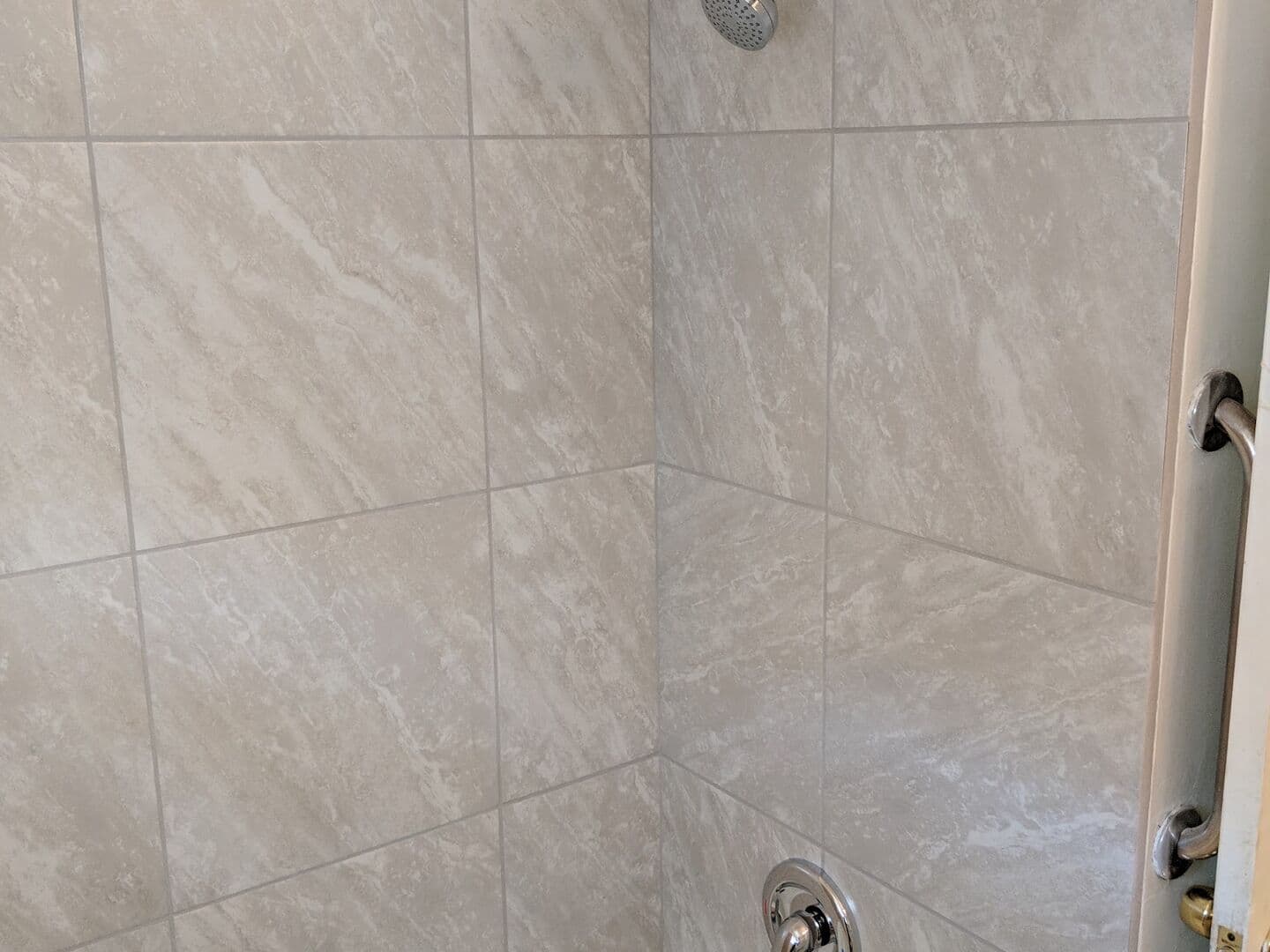Tub and shower surround in large-format grey stone-look porcelain