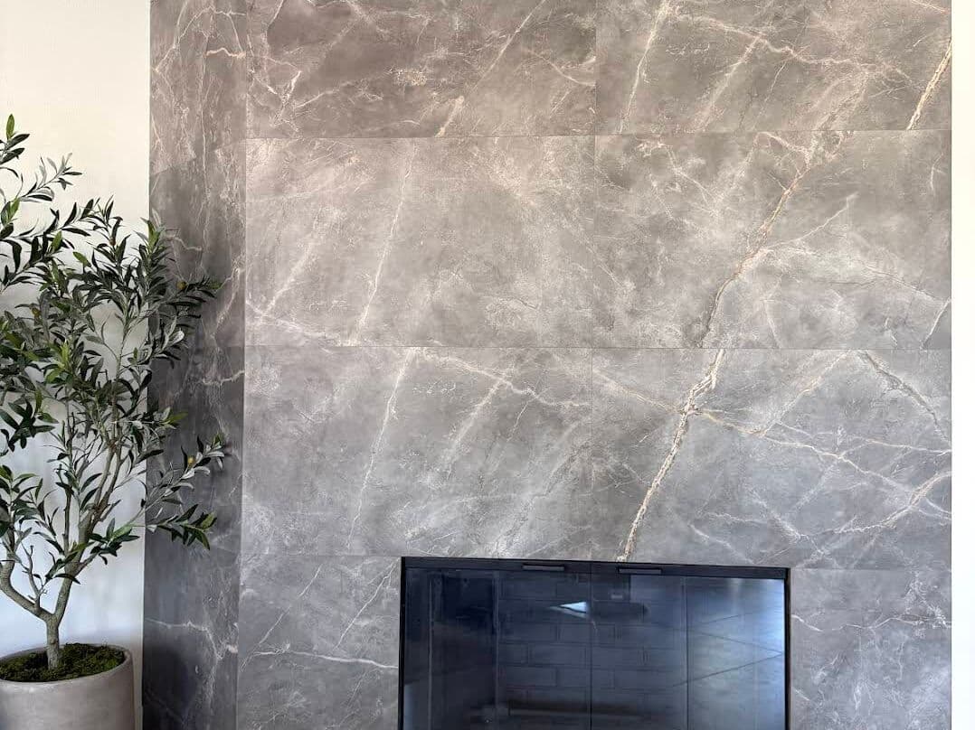 Floor-to-ceiling fireplace wall in grey marble-look large-format porcelain