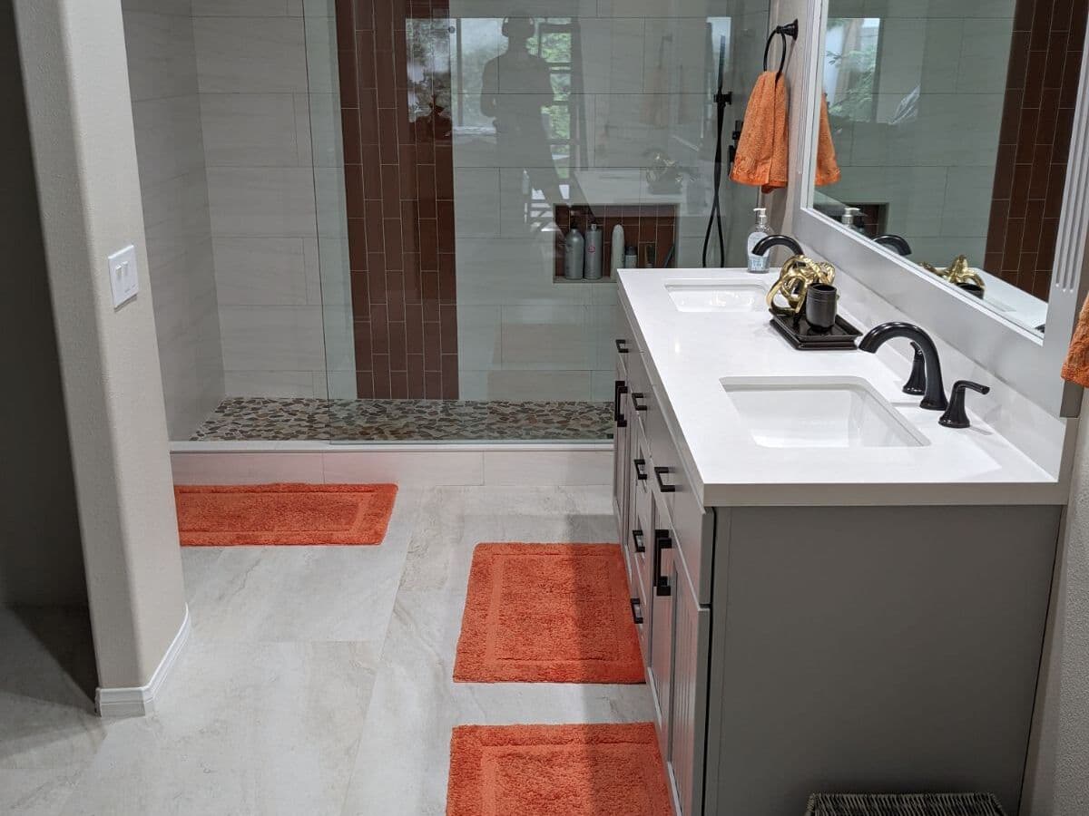 Master bathroom with a double vanity, wood-look porcelain floor and a tiled walk-in shower