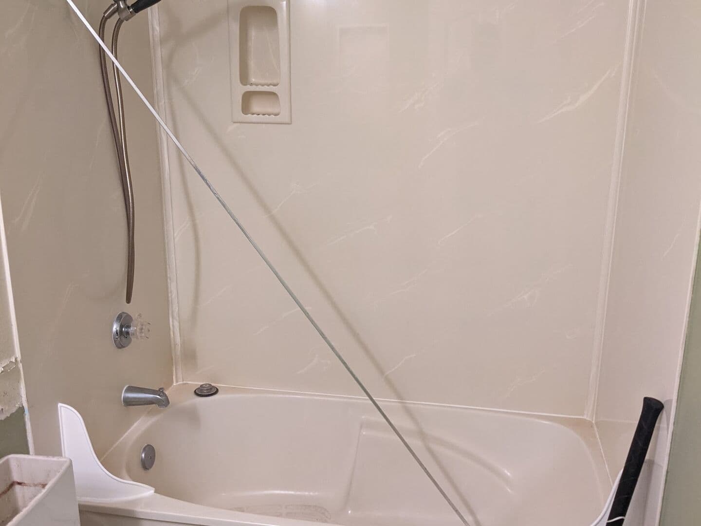 Before: one-piece fiberglass tub and shower surround in the alcove